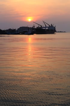 Cargo ship in the harbor at sunset