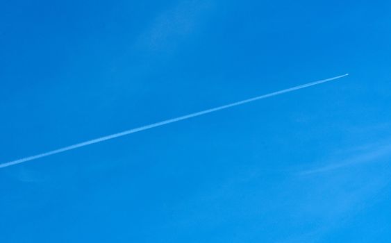 Diagonal airplane trace on a clear blue sky