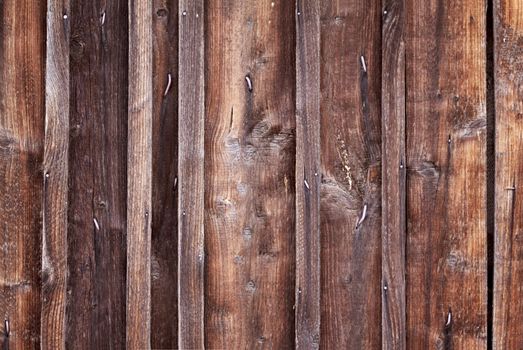 Close up on the brown wooden wall with nails, background