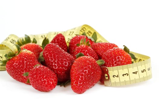Yellow measuring tape around a strawberry as a symbol of diet