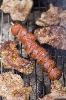 closeup on grilled sliced sausage and beef on a grill
