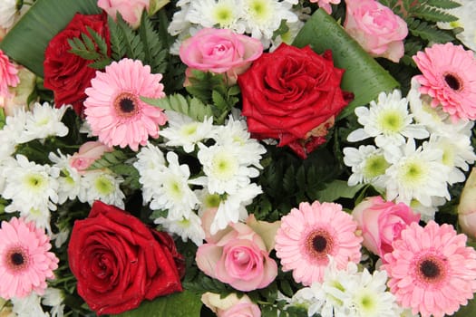 Red roses and pink gerberas in a mixed wedding centerpiece