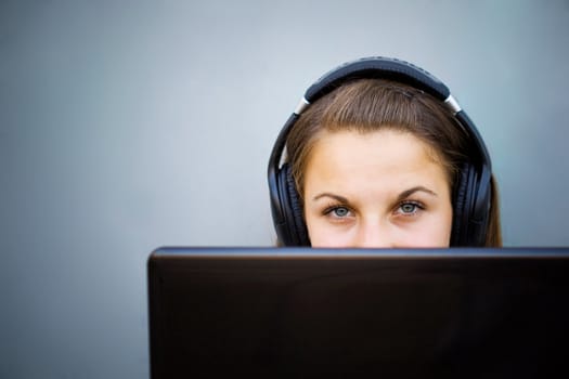 Young girl listening to music via laptop