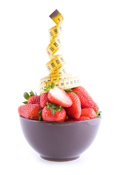 Fresh strawberries in a bowl with measure tape isolated on white