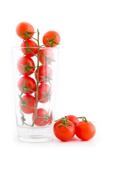 Small cocktail tomatoes in a glass isolated on white