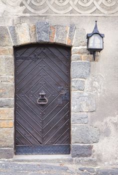Old wooden medieval door with steel knocker