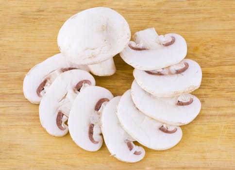 Sliced mushrooms on the wooden cutting board background