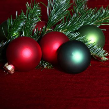 Pine needles and red and green Christmas baubles