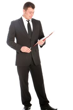 Full length studio portrait of a handsome young businessman in a stylish suit standing reading notes on a clipboard isolated on white