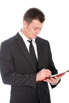 Upper body studio portrait of a handsome young businessman in a suit standing writing notes on a clipboard isolated on white