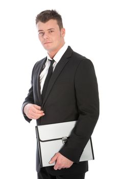 Serious good-looking young businessman in a suit holding a folder under his arm standing at an angle looking at the camera, upper body studio portrait isolated on white