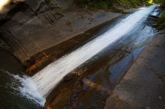 Sliding water over a rocky cliff in a lake