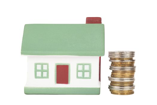 Little house toy and stack of coins isolated over white background