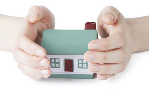 Little house toy covered by hands over white background