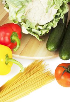 Vegetables (pepper, tomato, caulflower, cucumber) and spaghetti over white background