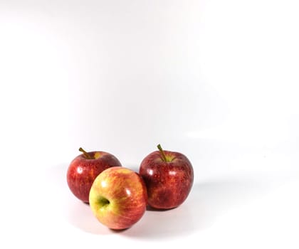 Red apples in white bowl, on white