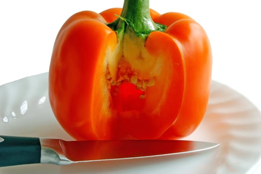 orange paprika with knife on the plate