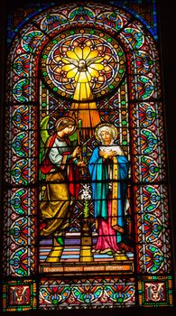 CATALONIA, SPAIN--OCTOBER 18, 2012  Stained glass angel tells Mary she will have Jesus holy spirit in Monestir Monastery of Montserrat, Barcelona, Catalonia, Spain on October 18, 2012.  Founded in the 9th century, destroyed in 1811 when French invaded Spain. Rebuilt in 1844 and now a Benedictine monastery.  Placa de Santa Maria.