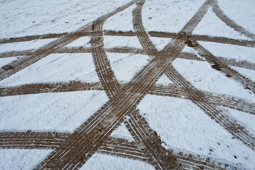 Car tire wheel tracks in different directions on the snow ground