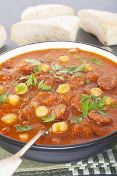 Spanish tomato soup with chorizo and chickpeas, served with bread, makes a hearty meal. Flavouring includes garlic, cumin and paprika.