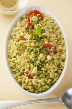 Couscous salad with spinach pesto and tomato.