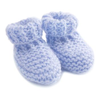 Hand knitted blue baby bootees on white background.