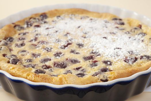 Famous French dessert, cherry clafoutis, with a sprinkle of icing sugar. Absolutely delicious! Shallow DOF, focus on foreground.