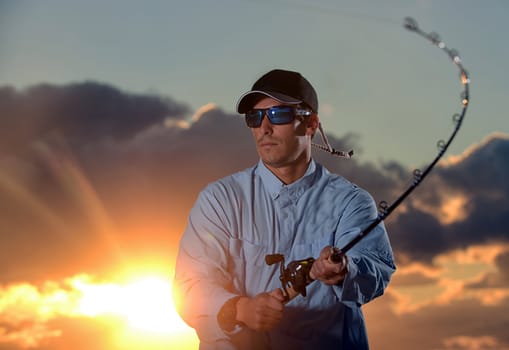 man fishing with beautiful sunrise in background