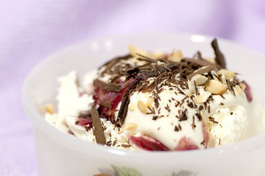 Dessert with cream, chocolate shaving, red jam and grated nuts