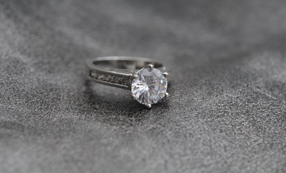 elegant engagement ring on gray textured backgound