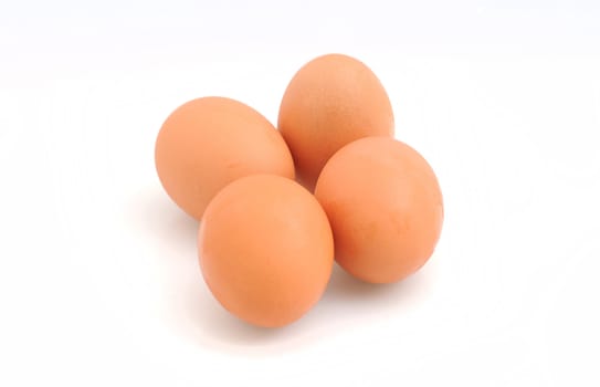 Four organic brown eggs on white background