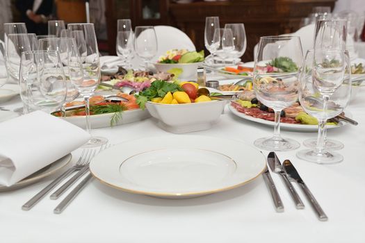 Served table with appetizers, dishes and glasses.