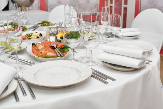 Served table with appetizers, dishes and glasses.