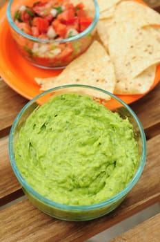 Bowl of guacamole made from fresh avocados, chips and salsa