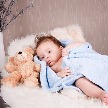 cute little baby todler infant lying on blanket with teddy bear 