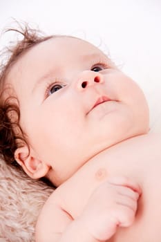 cute little baby infant toddler lying on white blanket smiling portrait