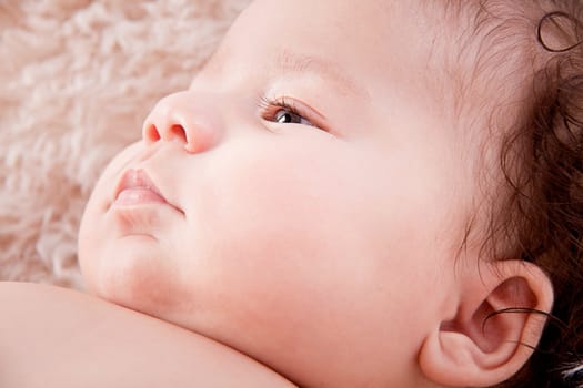 cute little baby infant toddler lying on white blanket smiling portrait