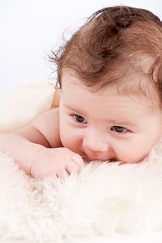 cute little baby infant toddler lying on white blanket smiling portrait
