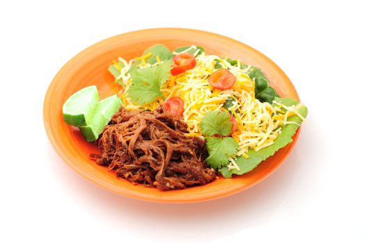 Orange plate of shredded beef with limes and a healthy salad