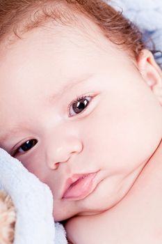 cute little baby infant toddler lying on white blanket smiling portrait