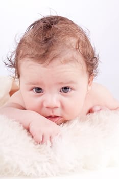 cute little baby infant toddler lying on white blanket smiling portrait