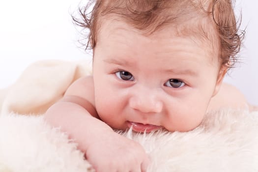 cute little baby infant toddler lying on white blanket smiling portrait