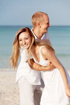 happy young couple in love having fun on the beach blue sky and sunshine 