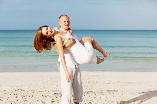 happy young couple in love having fun on the beach blue sky and sunshine 