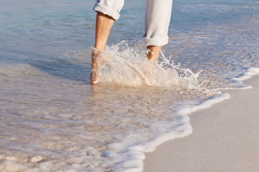 walking barefoot in the sand in summer holidays on beach