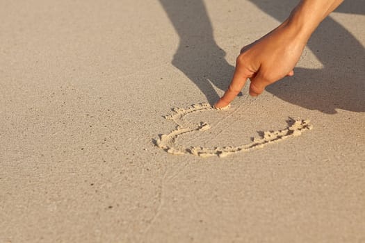 hand writing in sand in summer holiday vacation on beach 