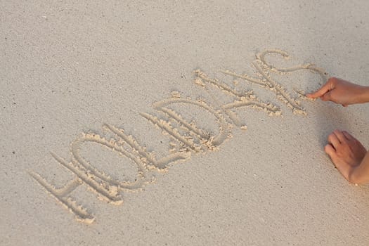 hand writing in sand in summer holiday vacation on beach 