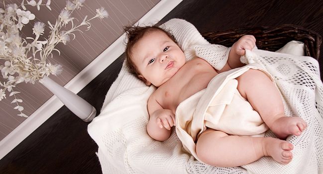 sweet little baby infant toddler on white  blanket in basket at home