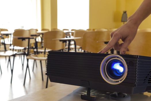 Digital projector being adjusted by a female hand