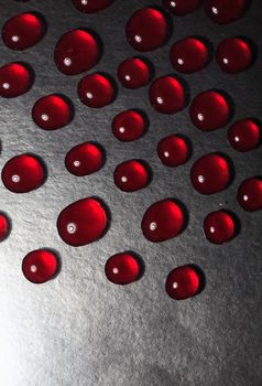 Closeup of set of red  drops on dark background 